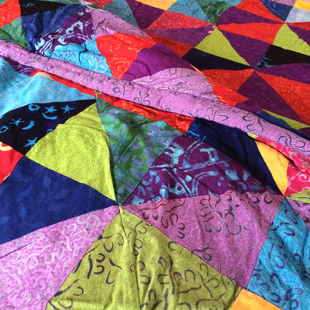 Colorful patchwork quilt on a bed.