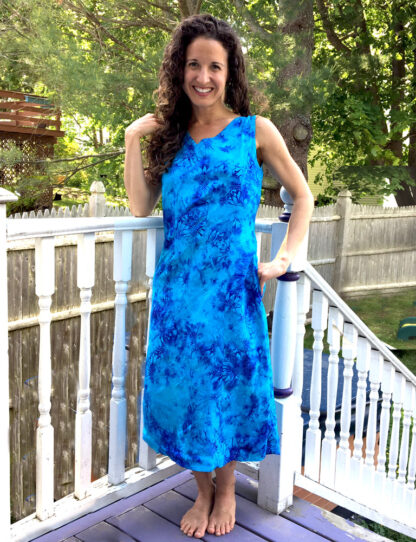 A woman standing on the porch of her home.