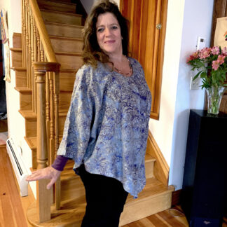 A woman standing in front of stairs and holding her hand out.