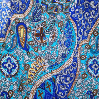 A close up of the fabric with blue and brown designs