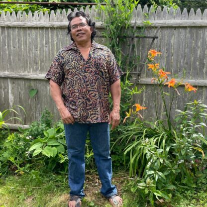 A man standing in front of some flowers