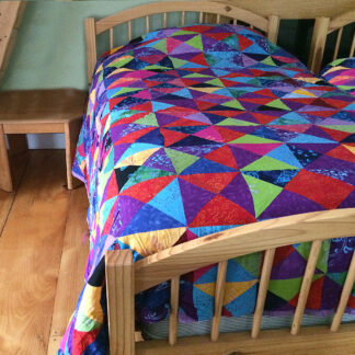 An abstract themed bed sheet on a wooden bed
