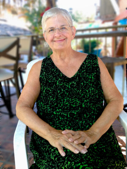 A woman sitting in a chair wearing glasses.