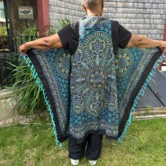 A man standing in the grass wearing a blue and black vest.