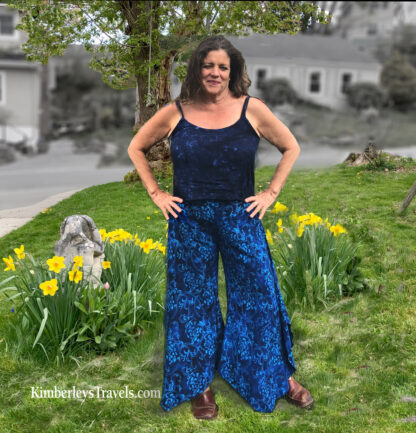 A woman standing in the grass with her hands on her hips.