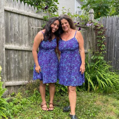 Two women in matching dresses posing for a picture.