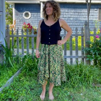 A woman standing in the grass wearing a skirt.
