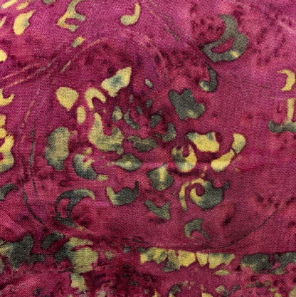 A close up of the fabric with green and yellow designs