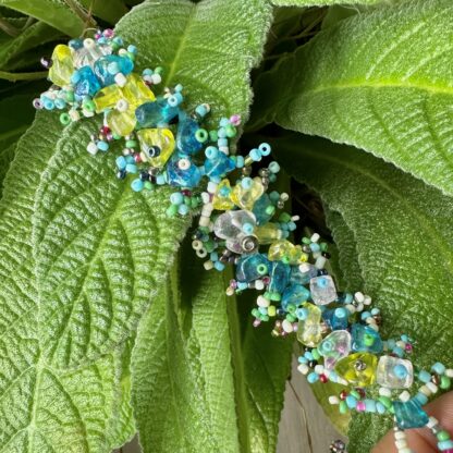 A close up of a bracelet on some green leaves